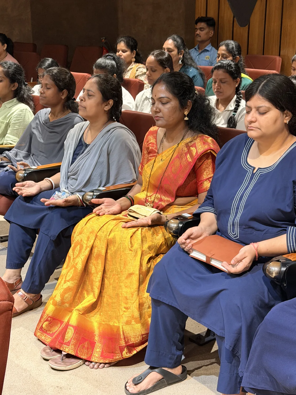 Participants seated with their eyes closed during a group wellbeing activity.