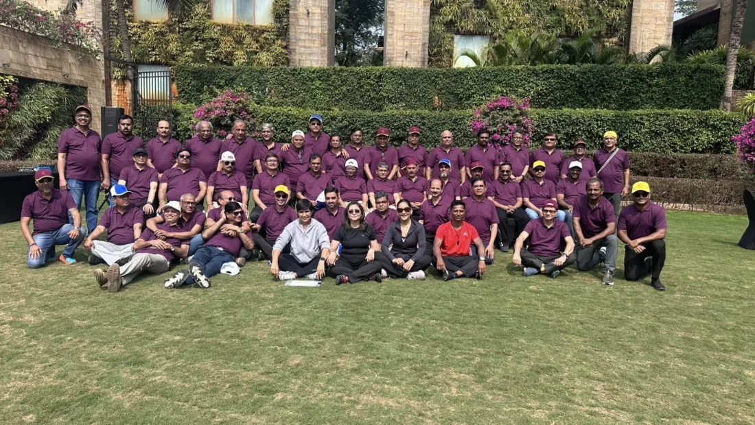 Participants in burgundy shirts gathered on a lawn at a Tsukuru event.